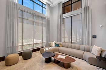 A living room with large windows and a couch and a table